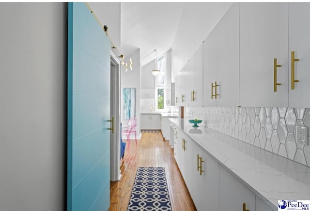bathroom featuring lofted ceiling, hardwood / wood-style floors, and decorative backsplash