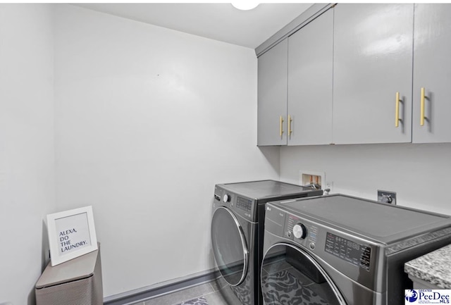 clothes washing area featuring cabinets and washing machine and clothes dryer