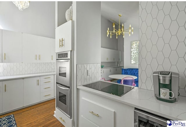 kitchen featuring pendant lighting, a notable chandelier, and white cabinetry