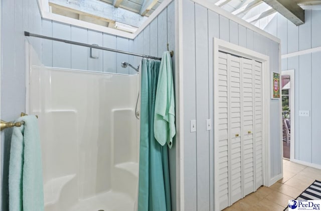 bathroom featuring tile patterned floors, wooden walls, and curtained shower