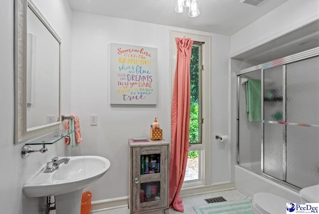 full bathroom with sink, toilet, and combined bath / shower with glass door
