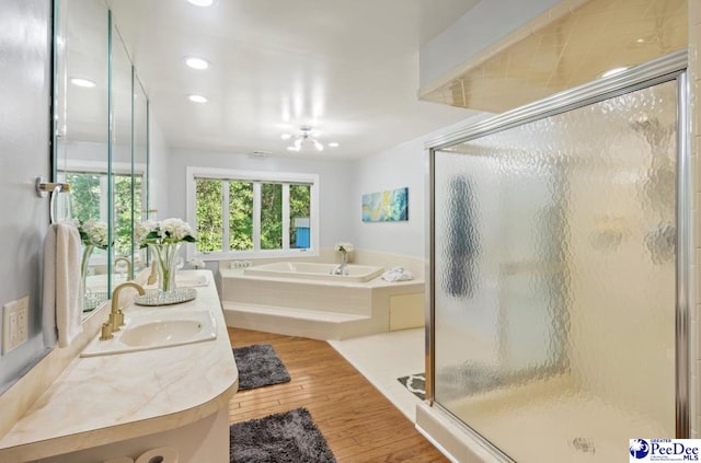 bathroom with independent shower and bath, wood-type flooring, and vanity