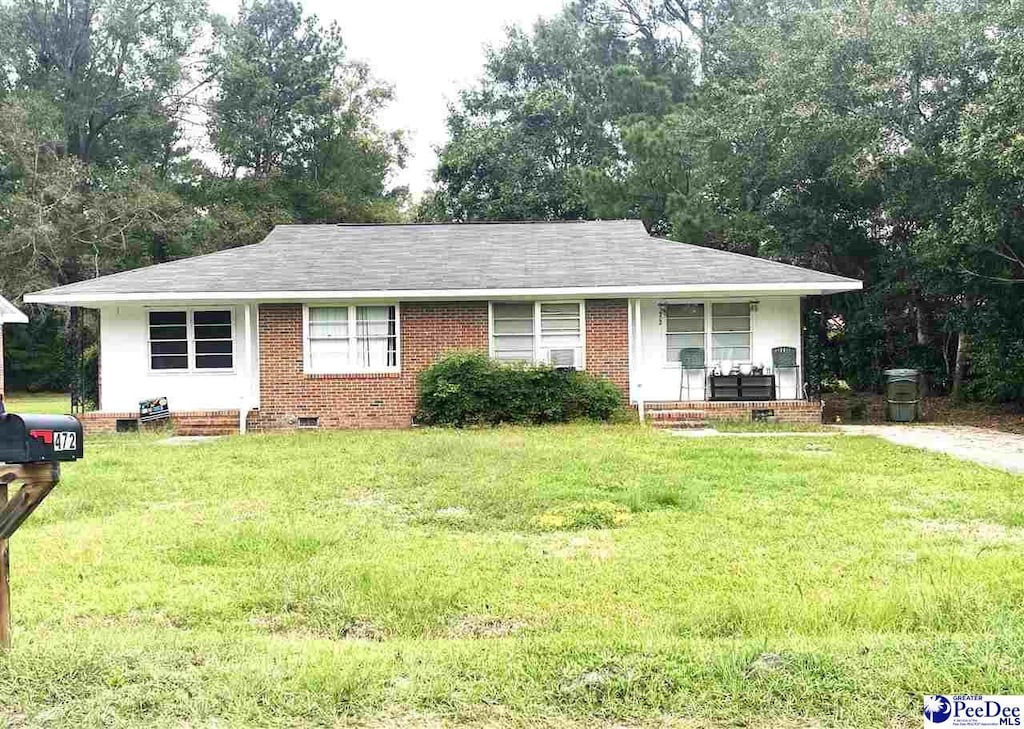 ranch-style house with covered porch and a front lawn