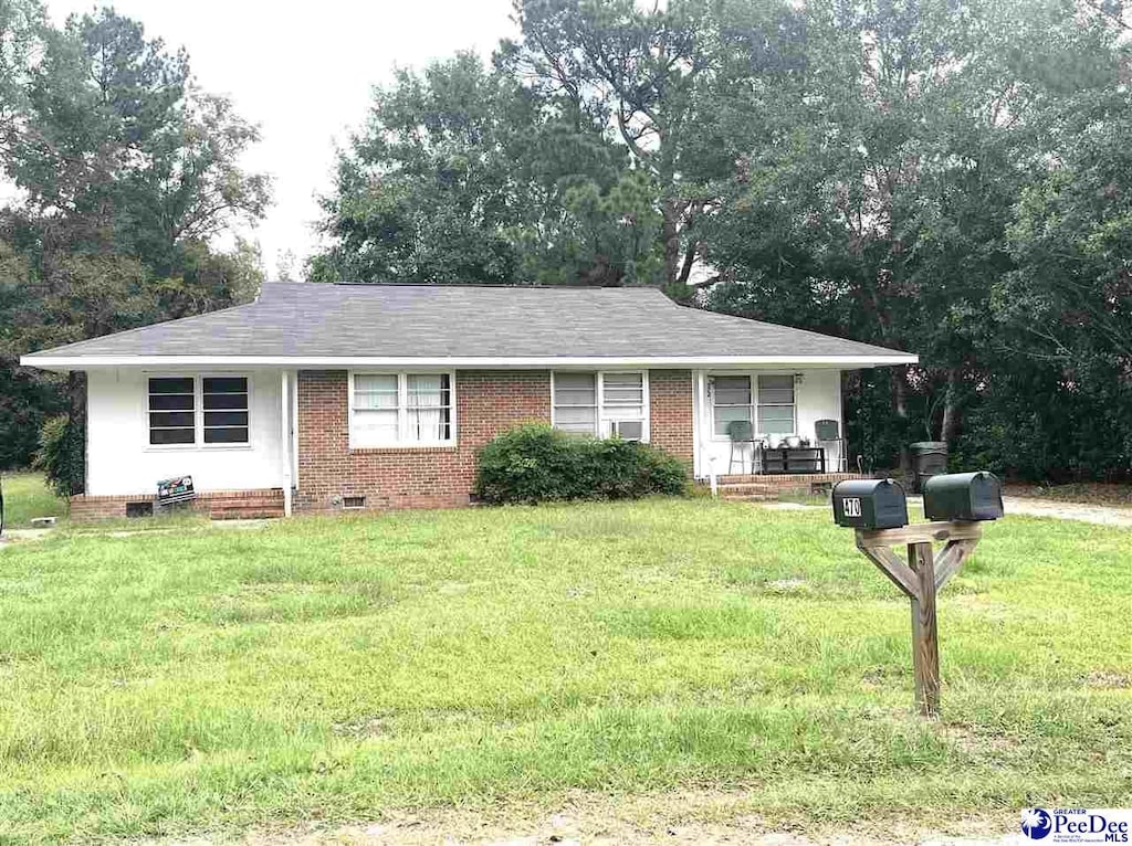 single story home with a front yard and covered porch