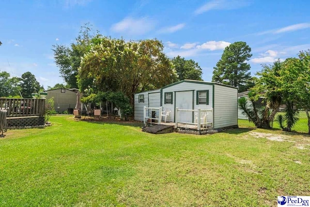 exterior space with an outbuilding, a deck, and a lawn