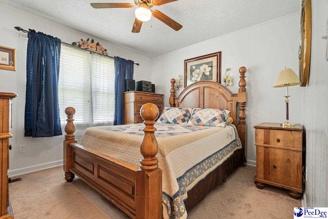 bedroom with light carpet, ceiling fan, crown molding, and a textured ceiling