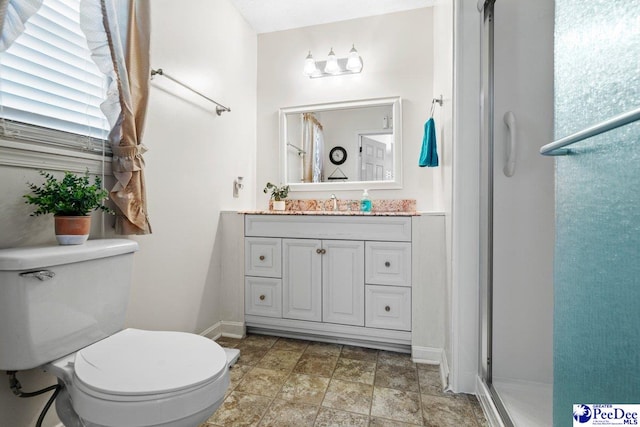 bathroom with vanity, a shower with shower door, and toilet