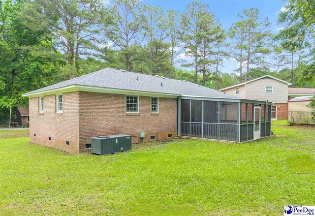 1341 Marshall Ave, Florence, SC 29501 - rear view of property featuring central air condition unit, crawl space, a sunroom, and a lawn