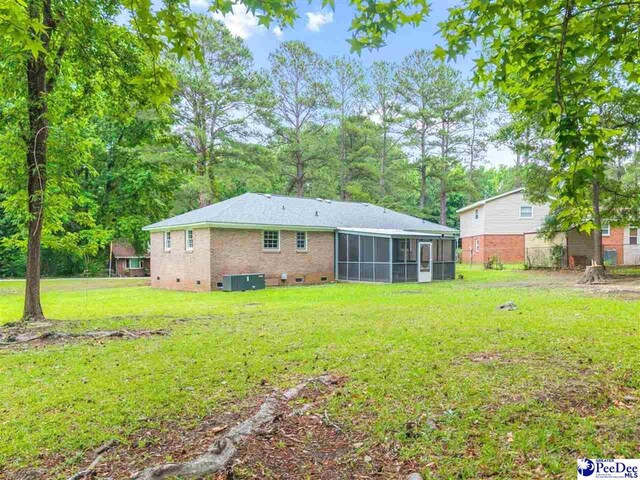 1341 Marshall Ave, Florence, SC 29501 - back of property with a sunroom, a lawn, cooling unit, and brick siding