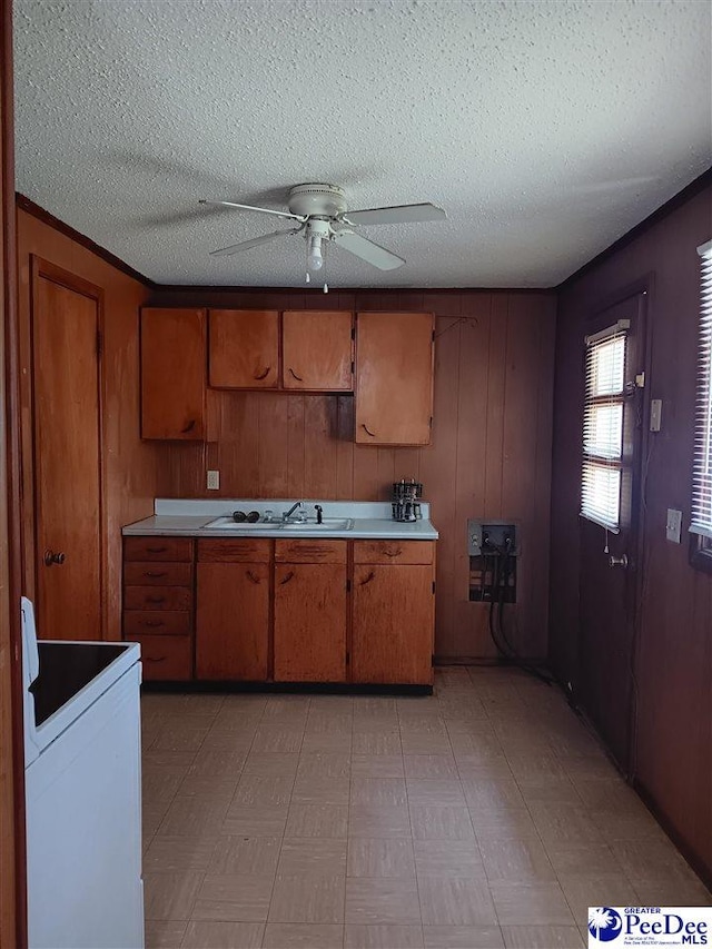 702 New Hampton Rd, Hartsville, SC 29550 - kitchen featuring white electric stove, a sink, brown cabinetry, a ceiling fan, and a textured ceiling