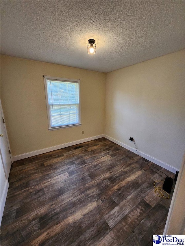 unfurnished room featuring dark hardwood / wood-style floors and a textured ceiling