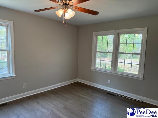 270 Quinby Cir, Quinby, SC 29506 - empty room featuring dark wood-style flooring, baseboards, and a ceiling fan