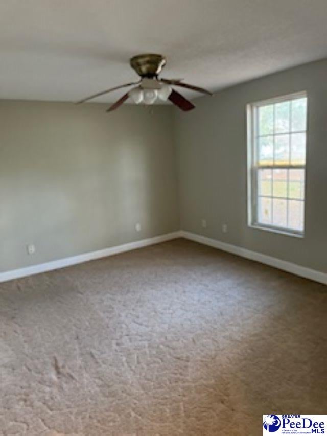 empty room with ceiling fan and carpet flooring