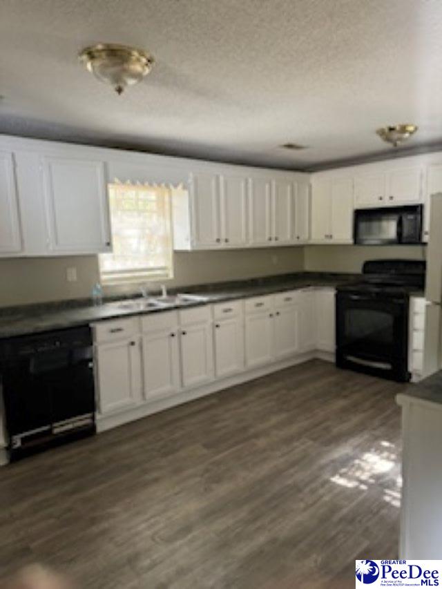 kitchen with white cabinets, sink, and black appliances