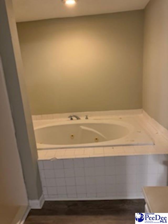 bathroom with vanity, hardwood / wood-style floors, and tiled bath