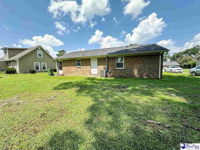 back of house with central AC and a lawn