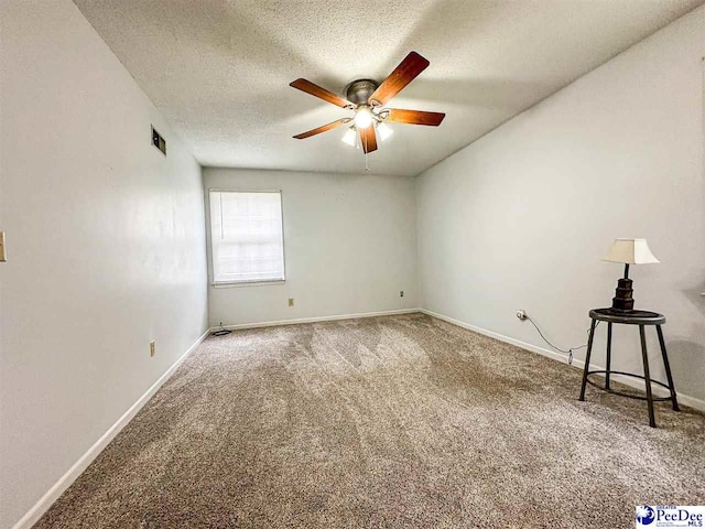 carpeted spare room featuring ceiling fan and a textured ceiling