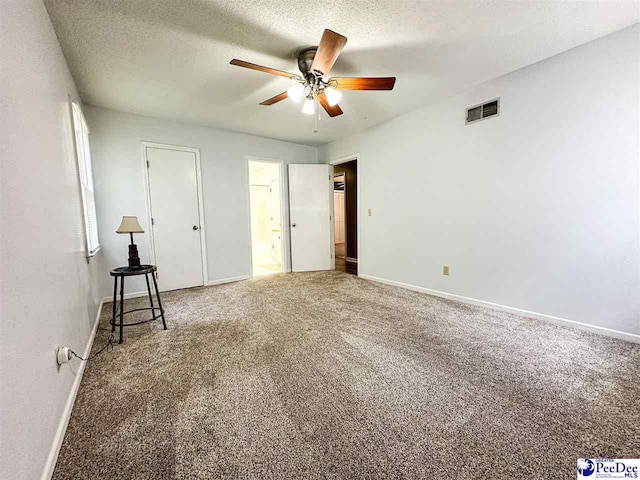 unfurnished bedroom featuring ceiling fan, carpet floors, and a textured ceiling