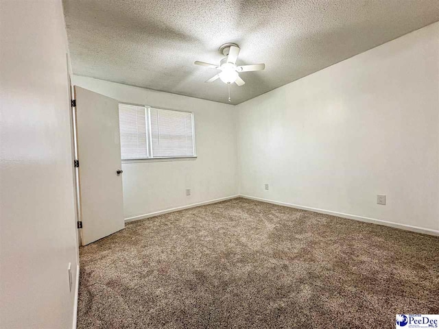 carpeted empty room featuring ceiling fan and a textured ceiling