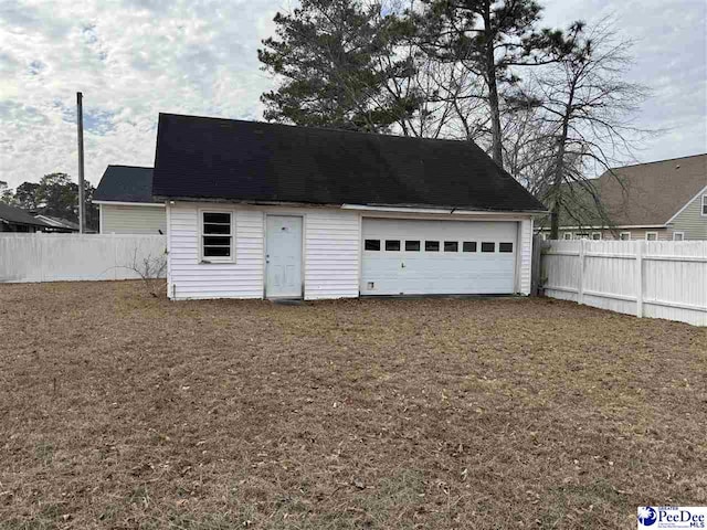 detached garage featuring fence