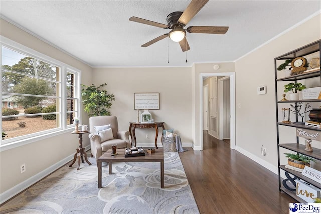 living area featuring ornamental molding, ceiling fan, a textured ceiling, and dark hardwood / wood-style flooring