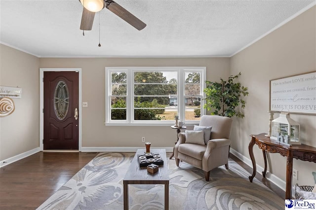 living area with ceiling fan, ornamental molding, dark hardwood / wood-style floors, and a textured ceiling