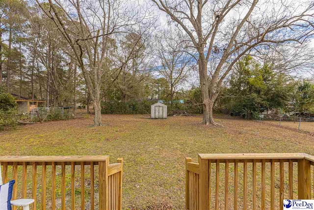 view of yard featuring a wooden deck and a shed