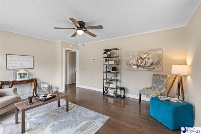 living room with ornamental molding, dark wood-type flooring, and ceiling fan