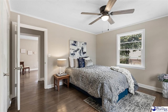 bedroom featuring ornamental molding, dark wood-type flooring, and ceiling fan