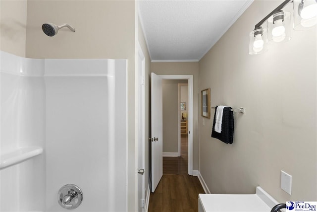 hall with crown molding, dark hardwood / wood-style floors, and a textured ceiling