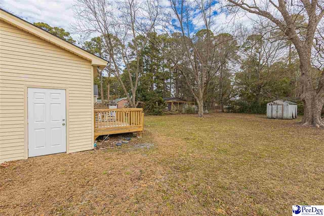 view of yard with a storage shed and a deck