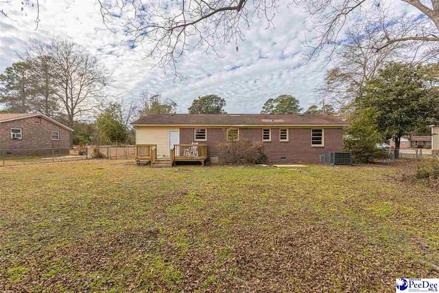 back of house with cooling unit, a wooden deck, and a yard