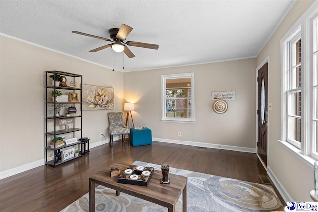 living room featuring dark hardwood / wood-style flooring, ceiling fan, crown molding, and a textured ceiling