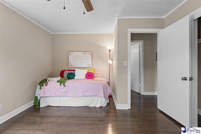 bedroom featuring a textured ceiling, dark wood-type flooring, ornamental molding, and ceiling fan