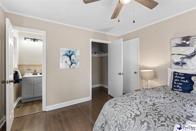 bedroom with crown molding, ensuite bath, dark hardwood / wood-style flooring, and a closet