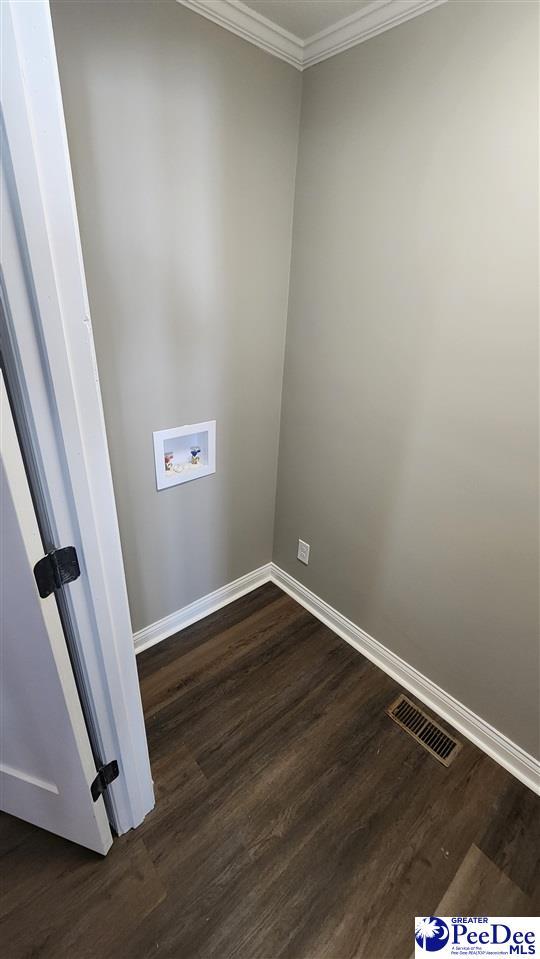 laundry area with dark wood-type flooring, ornamental molding, and hookup for a washing machine