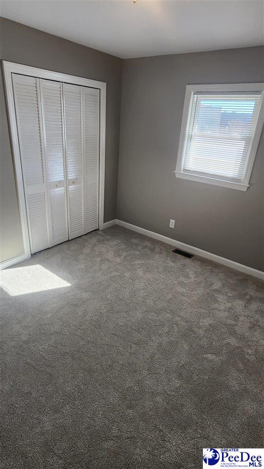 unfurnished bedroom featuring a closet and carpet flooring