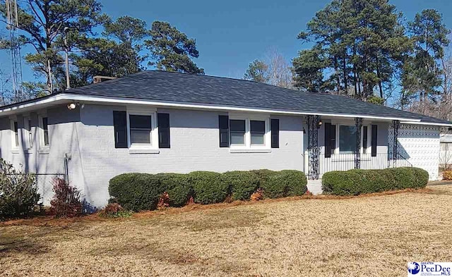 ranch-style home with a garage and a front yard