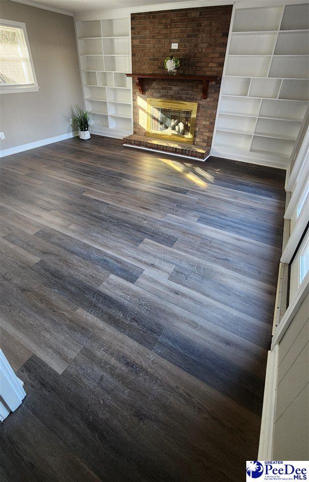 room details with a fireplace, built in features, and wood-type flooring