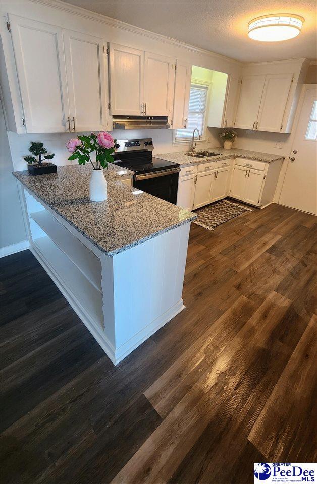 kitchen featuring stainless steel electric range oven, sink, and white cabinets