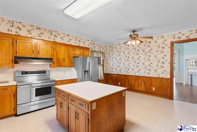 118 Ford Ave, Mullins, SC 29574 - kitchen with appliances with stainless steel finishes, under cabinet range hood, wallpapered walls, wainscoting, and light countertops
