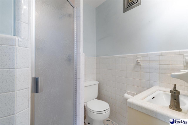118 Ford Ave, Mullins, SC 29574 - bathroom featuring a shower stall, tile walls, toilet, a wainscoted wall, and vanity