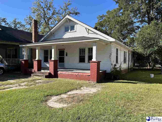 view of front of home with a porch and a front lawn