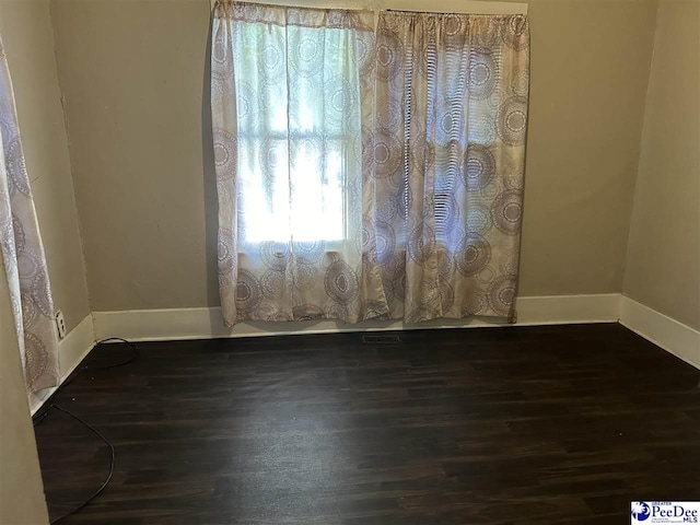 spare room with dark wood-type flooring