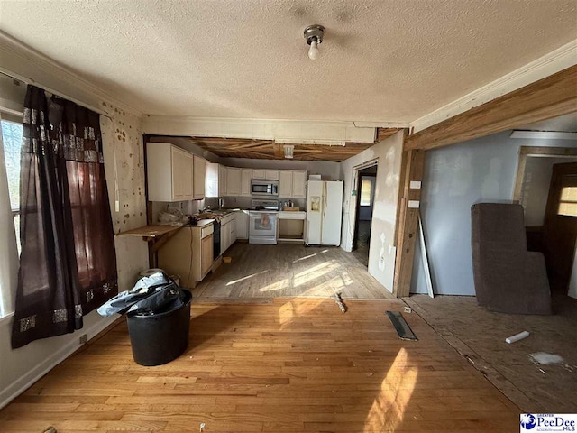 kitchen with white cabinets, light wood-type flooring, a textured ceiling, and white appliances