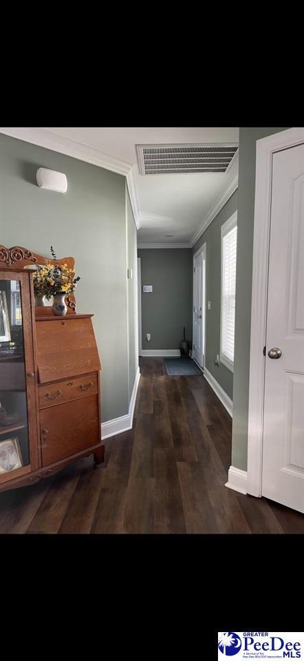 hallway with crown molding and dark hardwood / wood-style flooring