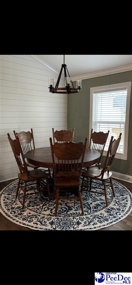 dining area featuring crown molding and hardwood / wood-style flooring