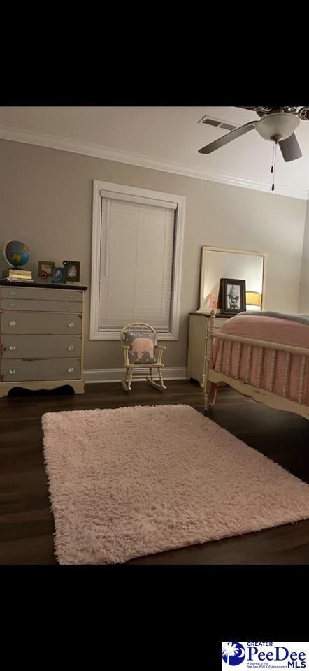 bedroom with ornamental molding, dark hardwood / wood-style floors, and ceiling fan