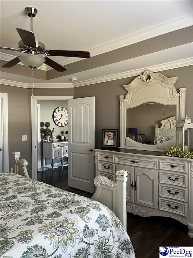 bedroom with a tray ceiling, crown molding, dark hardwood / wood-style floors, and ceiling fan