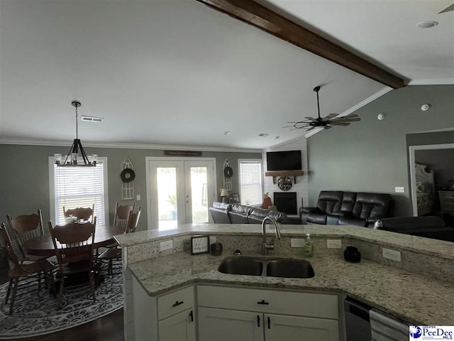 kitchen featuring sink, white cabinetry, hanging light fixtures, light stone counters, and lofted ceiling with beams